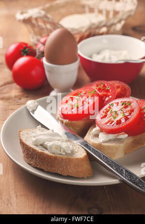 La colazione panino con formaggio e pomodoro, uova su uno sfondo di legno Foto Stock