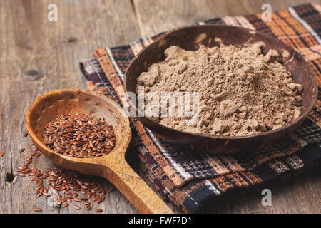 Farina di lino in una ciotola, semi di lino su uno sfondo di legno ( dieta priva di glutine ) Foto Stock