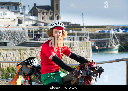 Porthleven, Cornwall, Regno Unito. Il 4 aprile 2016. Sean Conway è in giro per tutta la costa del Regno Unito in un incredibile triathlon. In primo luogo su una bicicletta di bambù e poi acceso da Scarborough a Brighton,ed infine il nuoto da Brighton a Lulworth Cove. Egli è completamente autoportanti, che porta tutti i suoi propri materiali di consumo e attrezzature. Credito: Simon Maycock/Alamy Live News Foto Stock