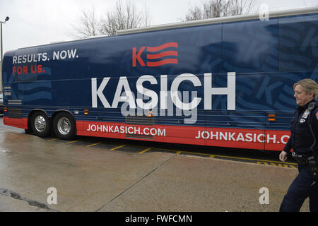 Hempstead, New York, Stati Uniti d'America. 4 apr, 2016. Una contea di Nassau funzionario di polizia è stazionato presso la John Kasich Bus della campagna che sta per lasciare il campus di pioggia, dopo che il candidato presidenziale repubblicano e governatore di Ohio, ospitato un municipio a Hofstra University David Mack Student Center di Long Island. Bus ha slogan "RISULTATI. Ora. Per noi." scritto sul lato. Credito: ZUMA Press, Inc./Alamy Live News Foto Stock