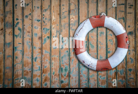 Salvagente appeso su un rustico di parete in legno Foto Stock