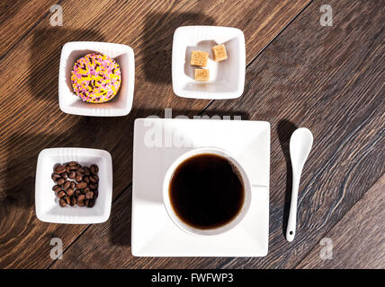 Tazza di caffè con lo zucchero di canna, i chicchi di caffè e biscotti di marshmallow in ceramica bianca Foto Stock