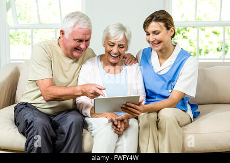 Felice infermiera e adulti senior holding tavoletta digitale Foto Stock