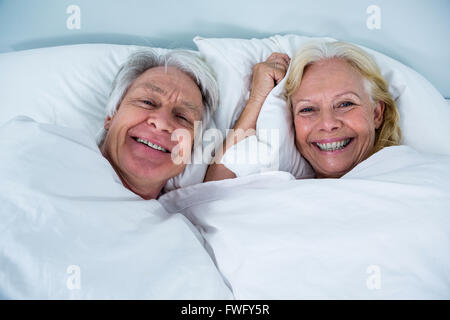 Ritratto di Allegro coppia senior di dormire sul letto Foto Stock