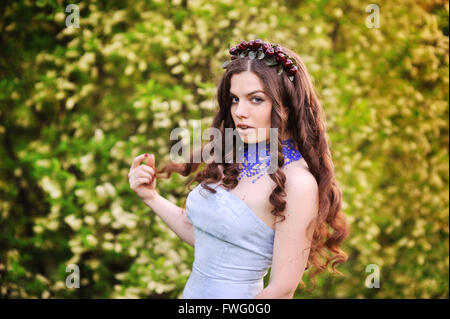 Bella ragazza in giardino con alberi di ciliegio Foto Stock