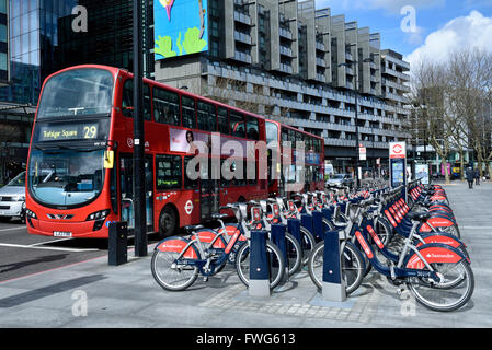 Santander cicli o Boris bike, noleggio biciclette sistema docking station con il numero 29 bus, angolo di Hampstead Road e Euston Roa Foto Stock