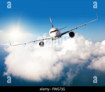 Aviogetti piano volare sopra le nuvole in luce del giorno Foto Stock