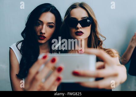 Due amiche prendendo un selfie Foto Stock