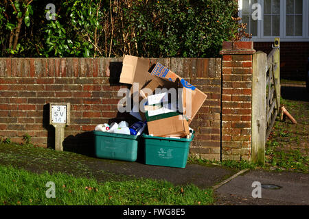 Contenitori in plastica verde con cartone e carta da riciclare in attesa di raccolta sul marciapiede esterno a Southborough, Kent, Inghilterra Foto Stock