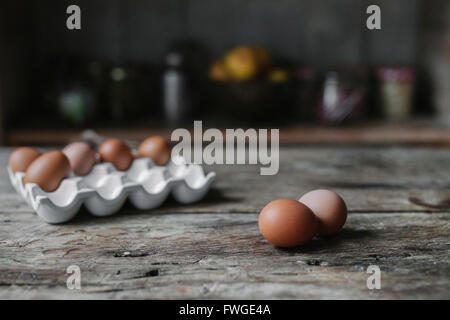 Fresco di gallina uova in una scatola e su un tavolo di legno. Foto Stock