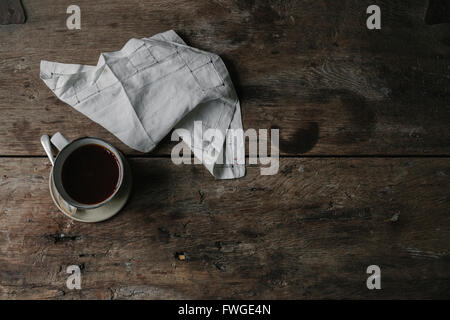 Una tazza di caffè e un tovagliolo in una tabella. Foto Stock