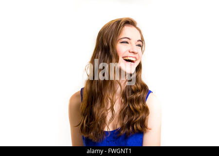 Un attraente teen in posa per una foto in interni in un studio di illuminazione contro uno sfondo bianco con un stile di moda per sentire la im Foto Stock