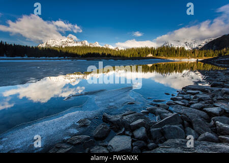 La molla del disgelo si scioglie il ghiaccio mentre vette innevate sono riflesse nel Lago Palu, Malenco Valley, Valtellina, Lombardia, Italia, Europa Foto Stock