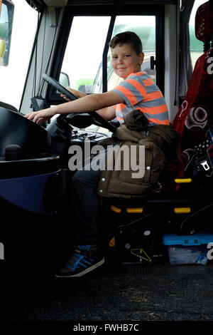 Un giovane ragazzo seduto in cabina di guida di un autobus in occasione di una mostra di classic vintage autobus southsea England Regno Unito Foto Stock