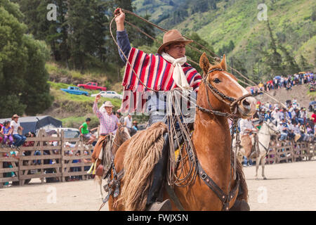 Banos, Ecuador - 30 Novembre 2014: Cowboy indigeni di equitazione ed oscillante lazo, Sud America In Banos Foto Stock