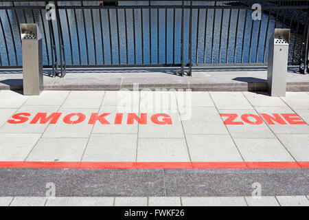 Contrassegni sul marciapiede designata zona fumatori in spazio aperto tra i blocchi degli uffici di Canary Wharf London Docklands Isle of Dogs Tower Hamlets England Regno Unito Foto Stock