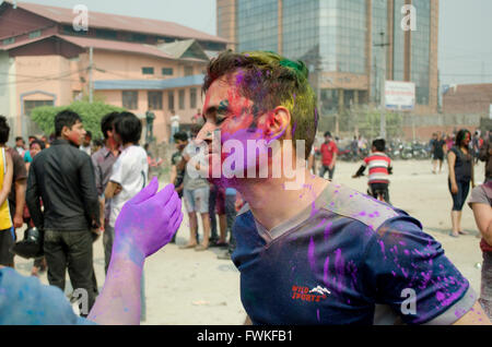 La gente che mette la vernice su ciascuno di loro si affaccia hile Che Celebra il festival di Holi a Kathmandu, Nepal. Foto Stock