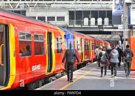 I pendolari ferroviari che lasciano il servizio passeggeri dei treni del Sud Ovest della stazione ferroviaria di Londra Waterloo si spostano verso le barriere di biglietteria Inghilterra Regno Unito Foto Stock