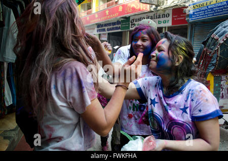 Donna che mette la vernice sui volti mentre Celebra il festival di Holi nelle strade di Kathmandu in Nepal, Asia Foto Stock