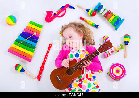 Bambino con strumenti musicali. Educazione musicale per i bambini. Colorata arte in legno giocattoli per bambini. Bambina la riproduzione di musica. Foto Stock
