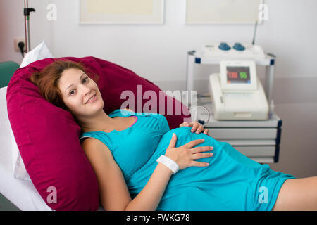 Madre di dare la nascita al bambino. Pazienti in stato di gravidanza in un ospedale a visita medica. Gravidanza elettronico monitor fetale Foto Stock