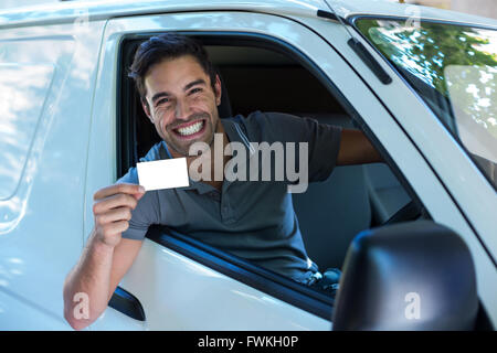 Bello driver con toothy sorridente che mostra la scheda vuota Foto Stock
