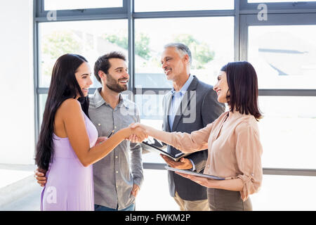Giovane agitando la mano con agente immobiliare Foto Stock