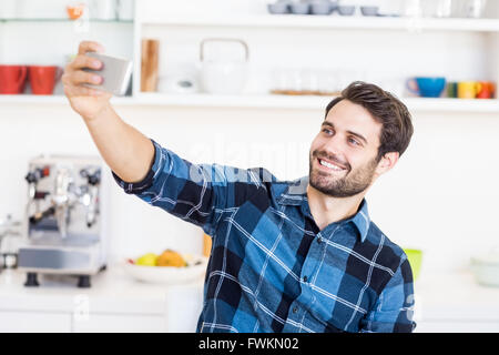 Un uomo è scattare una foto di sé con uno smartphone Foto Stock