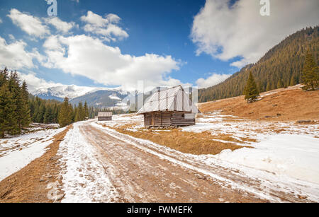 Capanne di legno da una strada sterrata nei monti Tatra, fine dell inverno e l'inizio della primavera, Polonia. Foto Stock