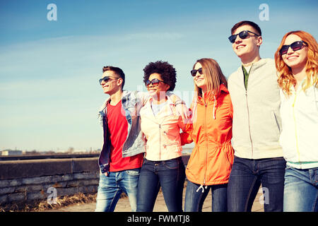 Happy amici adolescenti a piedi lungo una strada di città Foto Stock