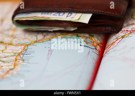 Le banconote in euro all'interno del portafoglio su una mappa geografica di Marsiglia, Francia Foto Stock