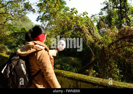 Donna prendere una maschera Foto Stock