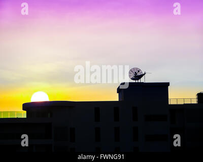 Tramonto al tetto e satellite in viola e arancione sky sera Foto Stock