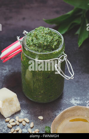 Aglio selvatico pesto. Ramsons (aglio selvatico) pesto nel preservare il vaso e ingredienti. Macro, il fuoco selettivo Foto Stock