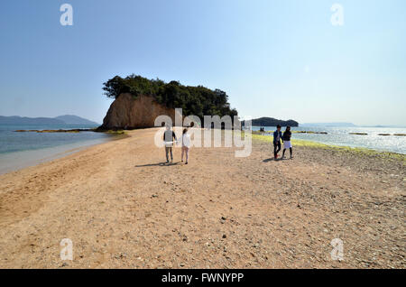 Kagawa, Giappone. 20 Mar, 2016. La gente a piedi su l'angelo strada che collega piccola isola da Shodoshima isola con una stretta sandbar a marea acqua due volte al giorno a Shodoshima isola nella Prefettura di Kagawa domenica 20 marzo, 2016. Si tratta di dette coppie a piedi sulla strada di sabbia verso la piccola isola, essi condurranno una felice vita insieme. © Yoshio Tsunoda/AFLO/Alamy Live News Foto Stock