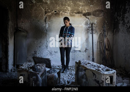 Ritratto di Meryem nella sua casa bruciata in idil, sirnak, Turchia 1 aprile 2016. Meryem, 21, i genitori si trasferì a Idil dopo il loro villaggio intorno Idil era stata bruciata dalle forze di stato nel 1993. Meryem nacque in questa casa nel 1995. Lei ha detto che ha sentito la stessa storia dai suoi genitori e ora sta succedendo di nuovo. Meryem ha lavorato in Istanbul con la sorella, nell'industria tessile per 3 anni e lei era appena tornato in idil negli ultimi 7 mesi. Essi rimanere in una tenda nella periferia di Idil adesso. Idil, Sirnak, TURCHIA - 01/04/2016 Foto Stock