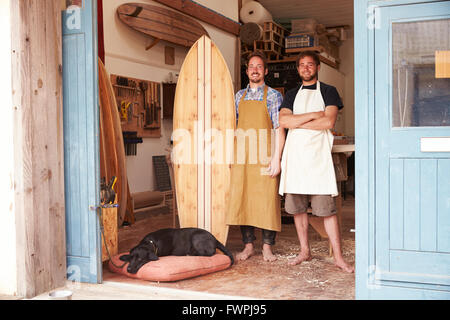 Ritratto di falegnami rendendo le tavole da surf su misura in officina Foto Stock