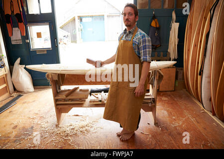 Ritratto di falegname rendendo le tavole da surf su misura in officina Foto Stock