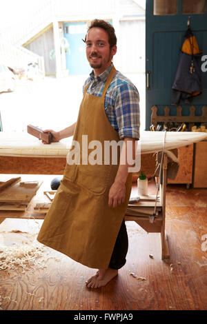 Ritratto di falegname rendendo le tavole da surf su misura in officina Foto Stock