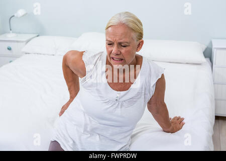 Senior donna che soffre di dolori alla schiena a casa Foto Stock