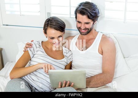 Giovane con tavoletta digitale mentre è appoggiato sul basamento Foto Stock