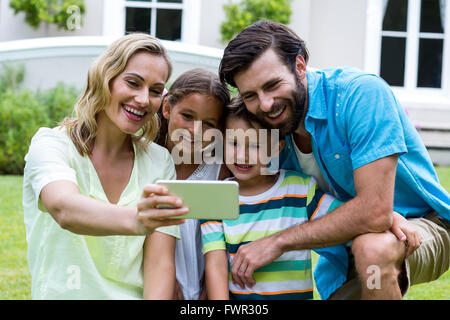 Madre tenendo selfie con la famiglia in cantiere Foto Stock