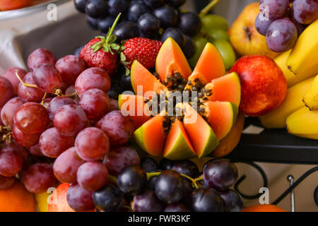 Diversi tipi di uve, papaia e banane su un tavolo Foto Stock