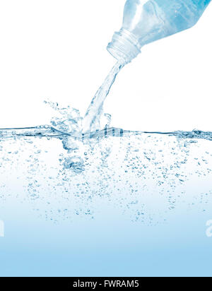 PLastic water bottle pouring and splashing against blue background. Foto Stock