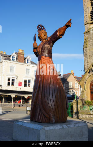 Scolpita in legno statue di Alice nel Paese delle Meraviglie caratteri di Llandudno, Denbighshire, il Galles del Nord. Foto Stock
