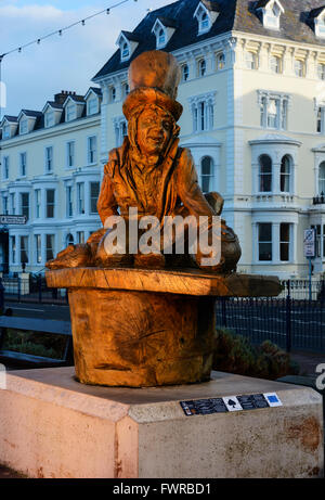 Scolpita in legno statue di Alice nel Paese delle Meraviglie caratteri di Llandudno, Denbighshire, il Galles del Nord. Foto Stock
