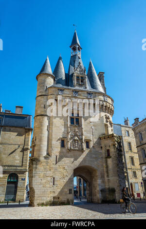 Ragazza in bici anteriore di rotolamento di Porte Cailhau gate, vista dalla Place du Palais. Bordeaux Aquitania, Francia. Foto Stock