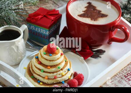 Natale la colazione su un vassoio di frittelle e caffè con cioccolato spolverata Foto Stock