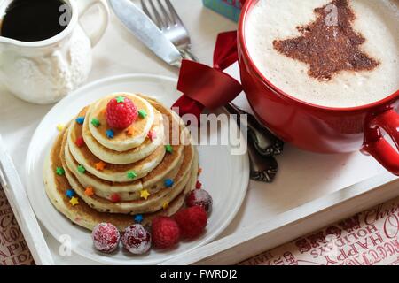 Natale la colazione su un vassoio di frittelle e caffè con cioccolato spolverata Foto Stock