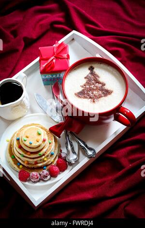 Natale la colazione su un vassoio di frittelle e caffè con cioccolato spolverata Foto Stock